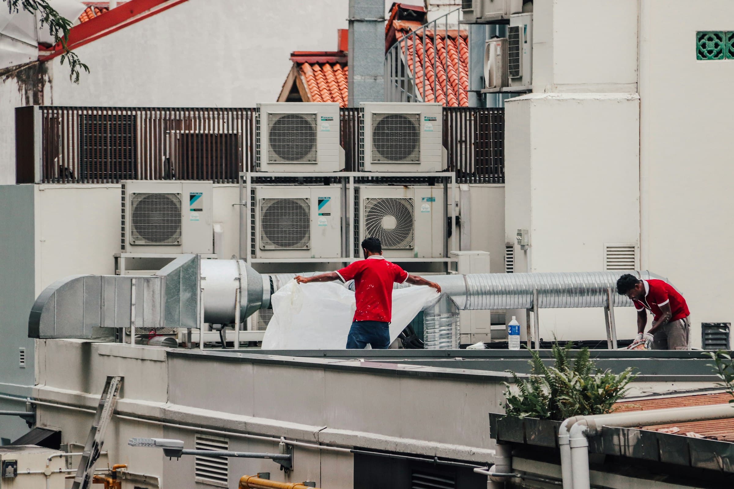HVAC technicians working on rooftop condenser units